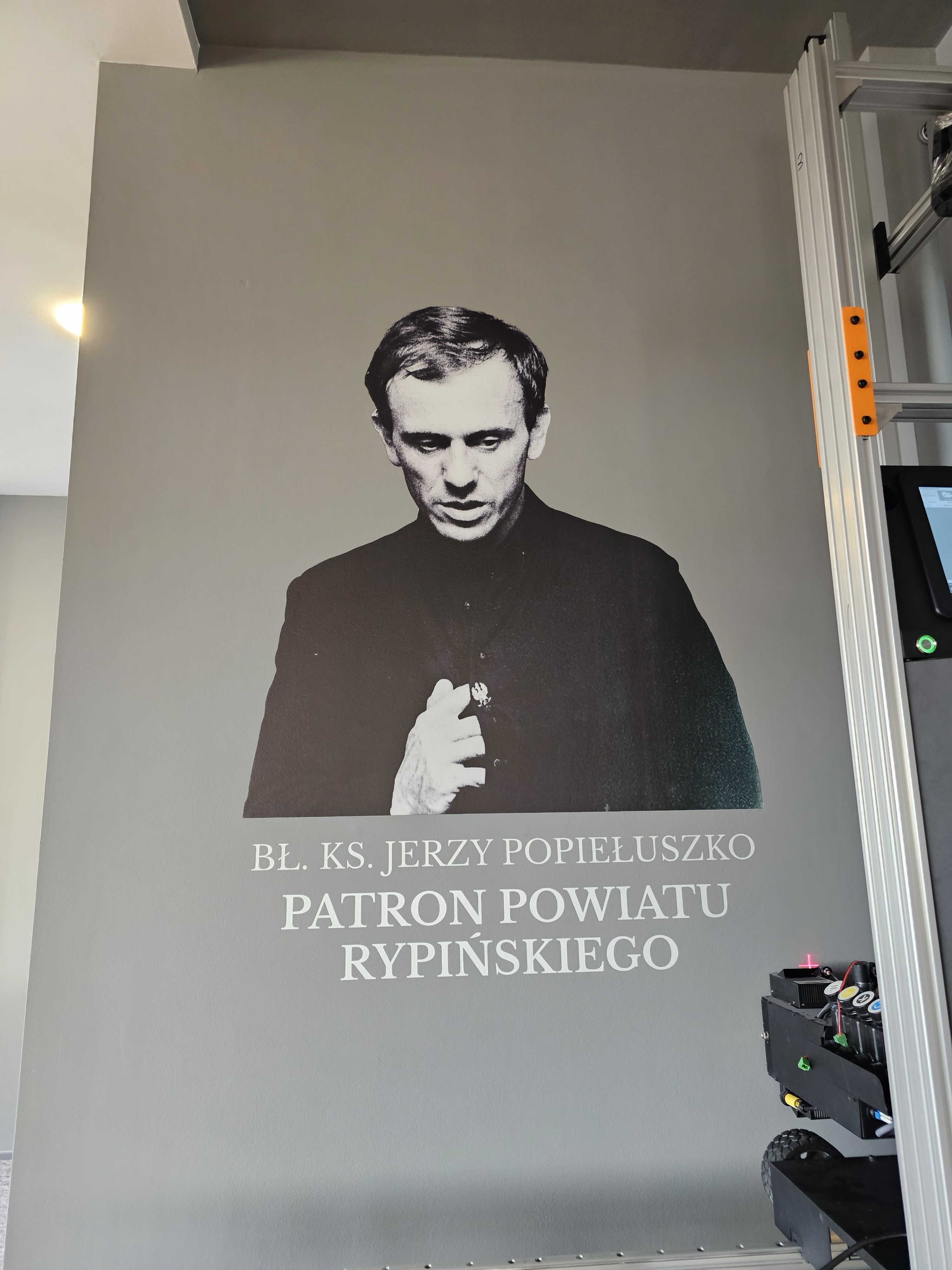 Portret błogosławionego księdza Jerzego Popiełuszki wydrukowany na ścianie starostwa w Rypinie